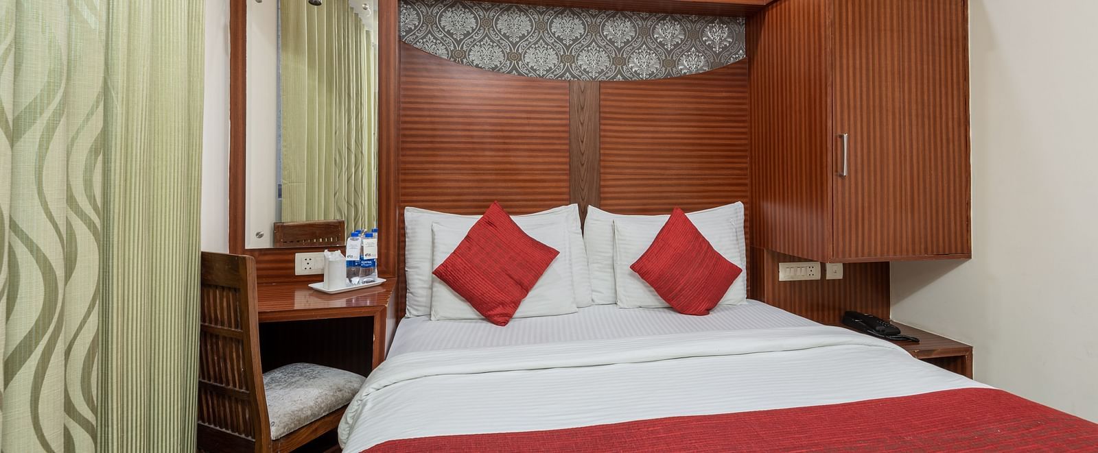 Bedroom with a king size bed and a bottled water and a glass placed next to it  at DLS Hotels The Rock Castle.